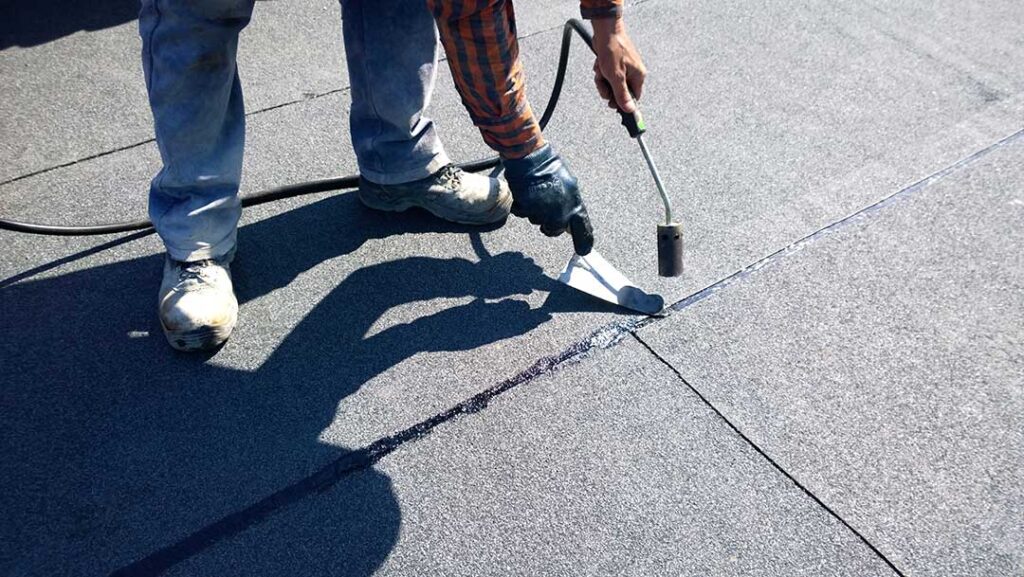 Roof replacement underway on a home while an attic inspection checks for damp insulation and mold.